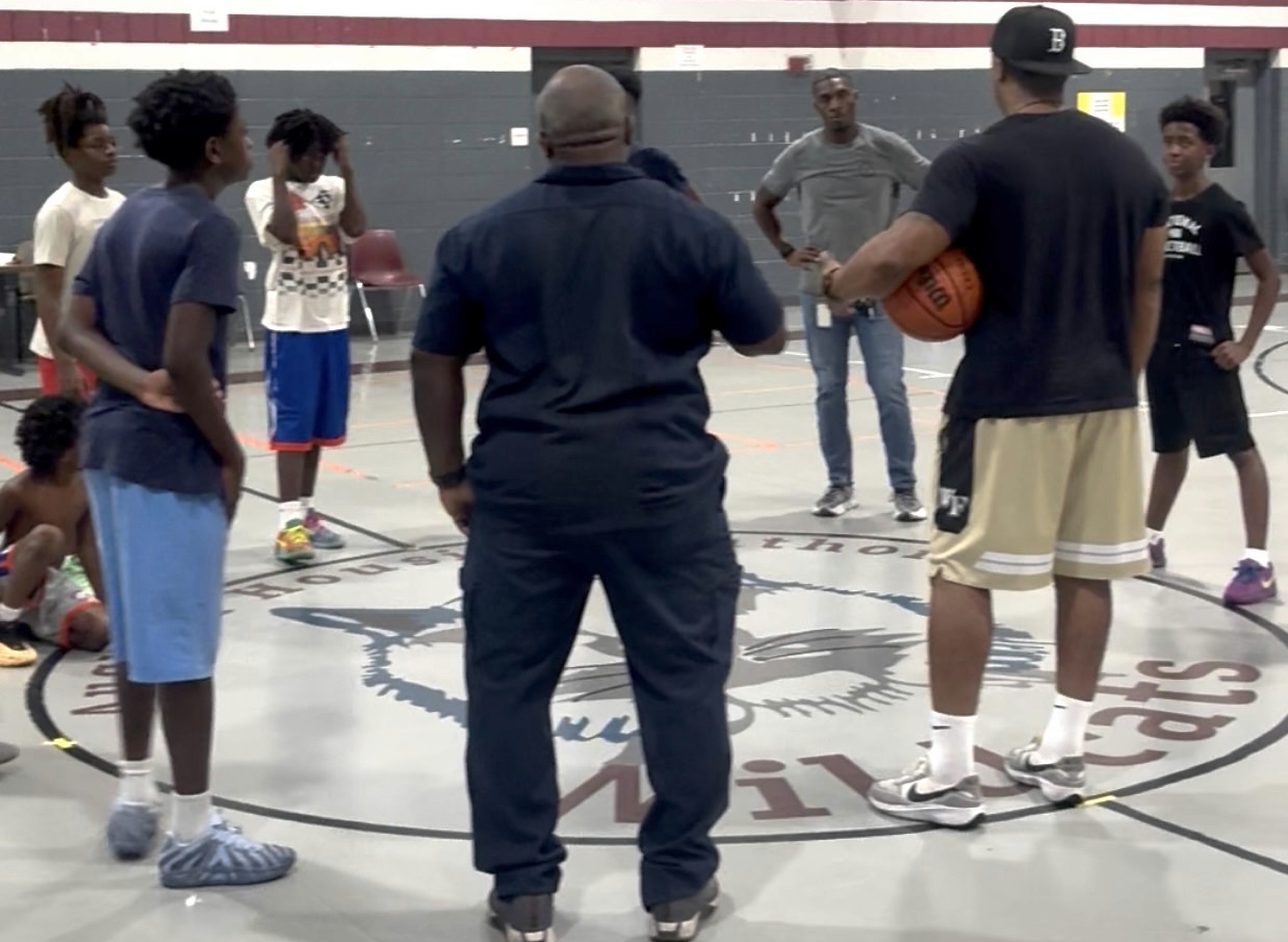 N.O.W. Wolves coaches and young athletes gathered together on the basketball court